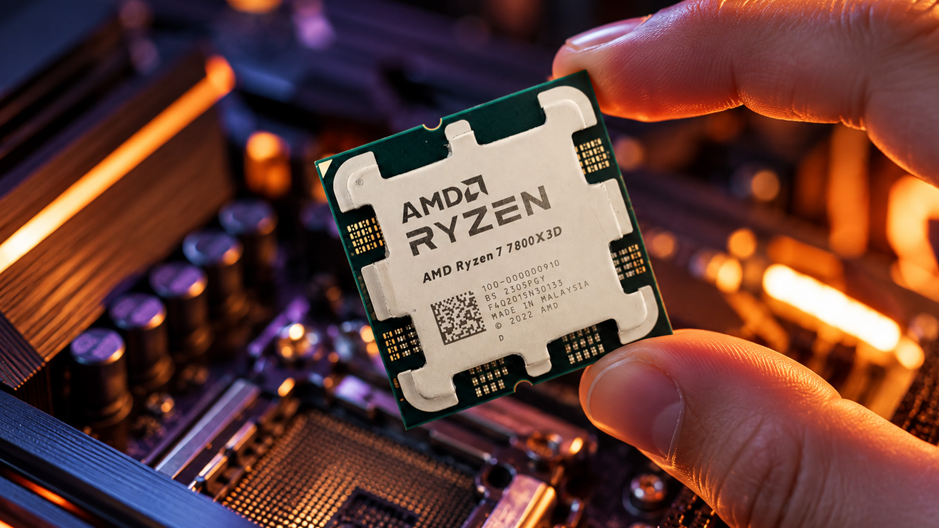 A person holding an AMD Ryzen processor chip over a motherboard socket.