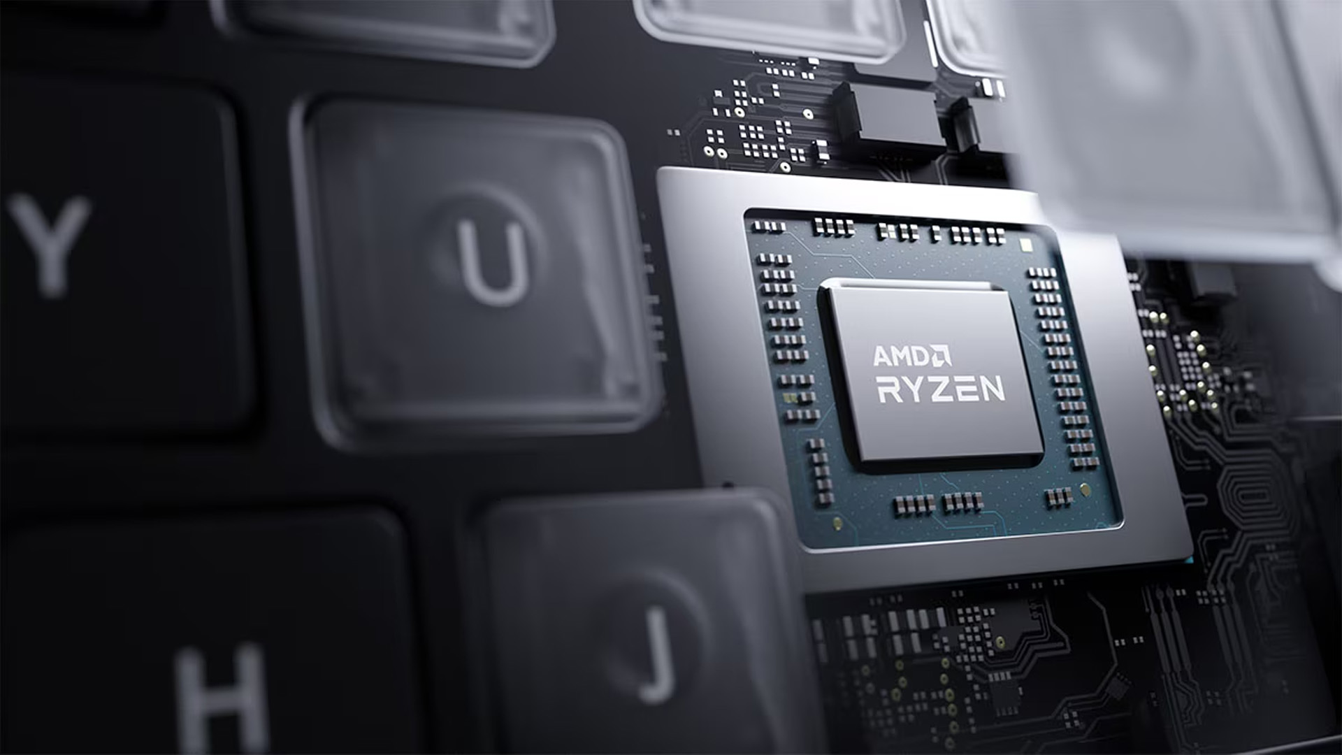 AMD Ryzen processor chip integrated on a laptop motherboard beside keyboard keys.