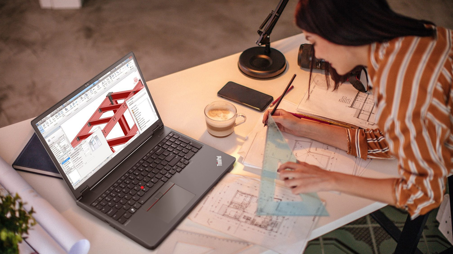 An architect using a Lenovo ThinkPad laptop to design 3D structural building models.