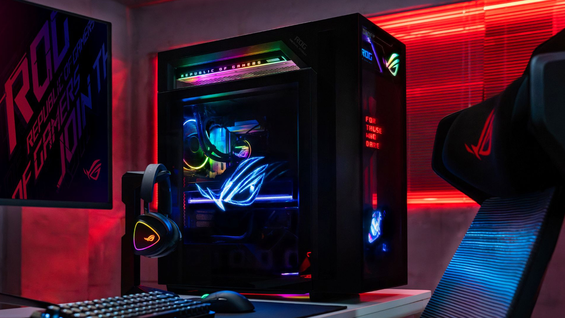 ASUS ROG gaming desktop PC setup with RGB lighting in a red illuminated room.