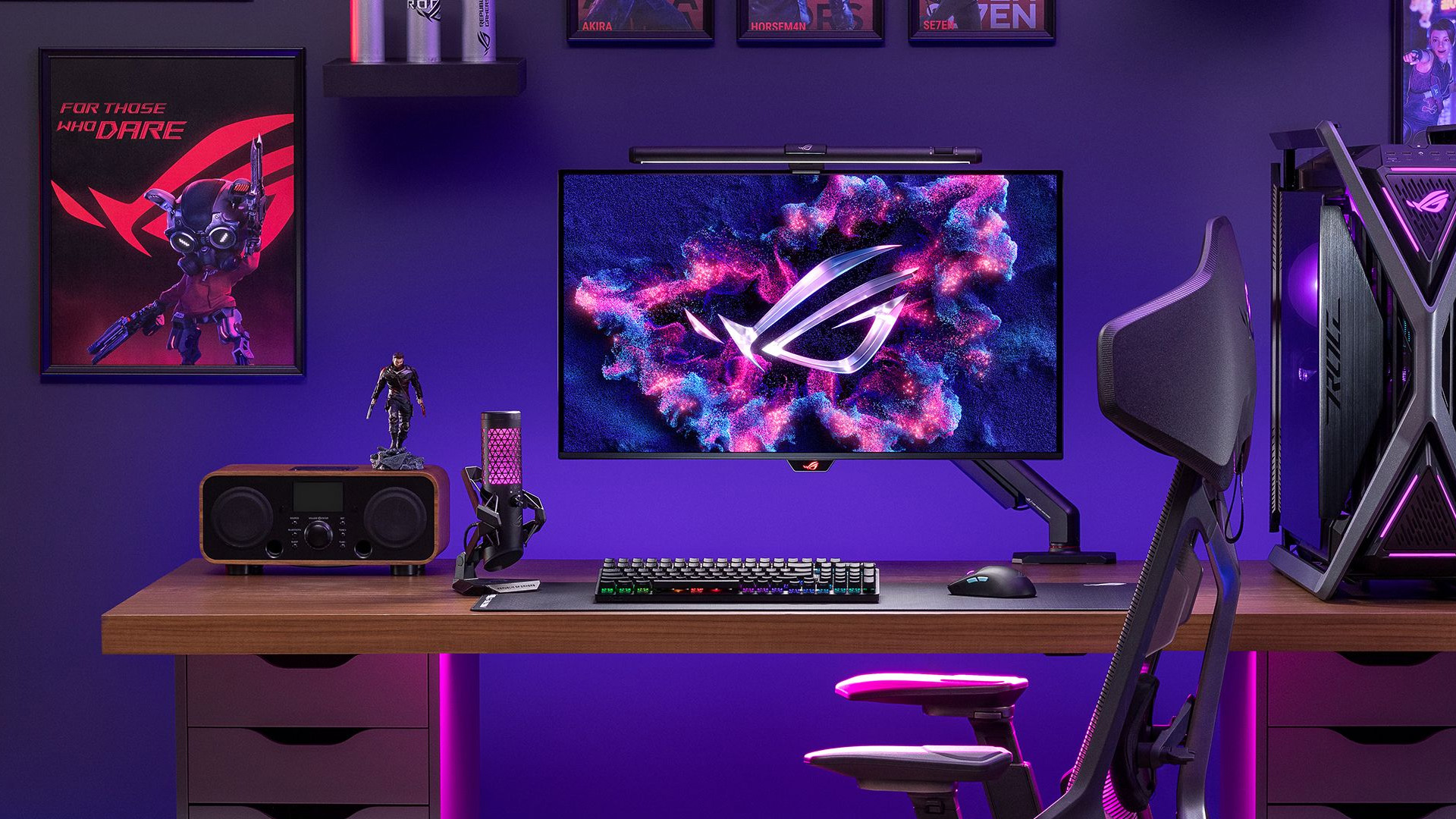 ASUS ROG gaming monitor mounted on a desk arm in a purple-lit setup.