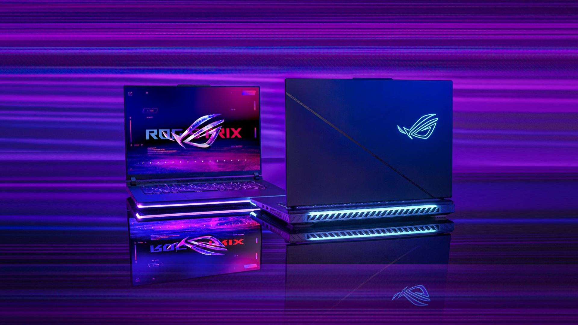 ASUS ROG Strix gaming laptops showcasing colorful RGB lighting on reflective desk.