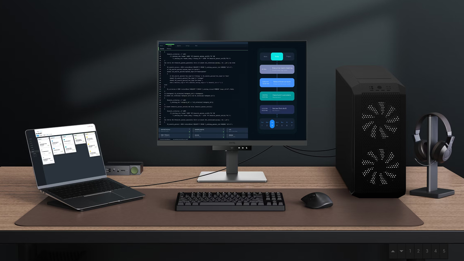 BenQ monitor setup on a wooden desk connected to a laptop and desktop PC.