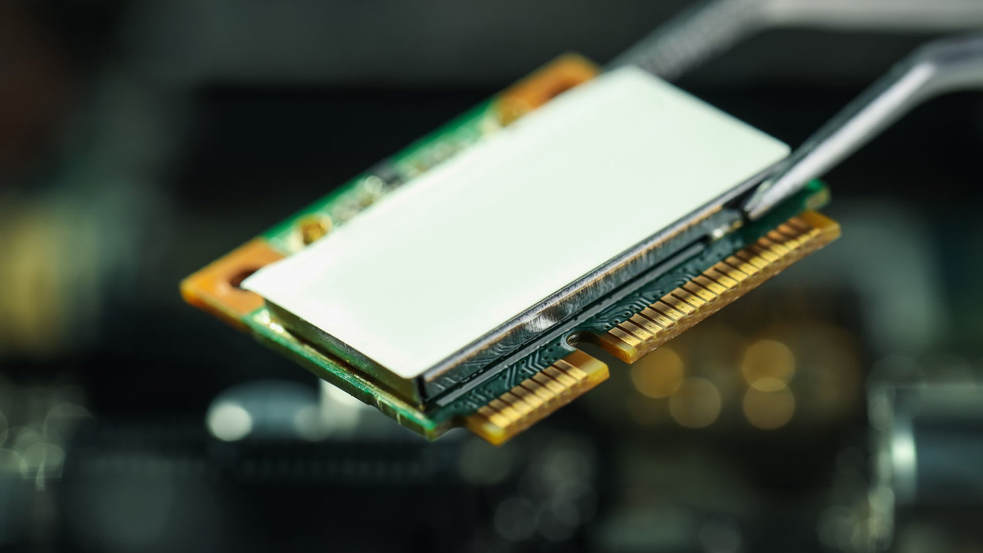 Close-up of an M.2 Wi-Fi card being held with tweezers.