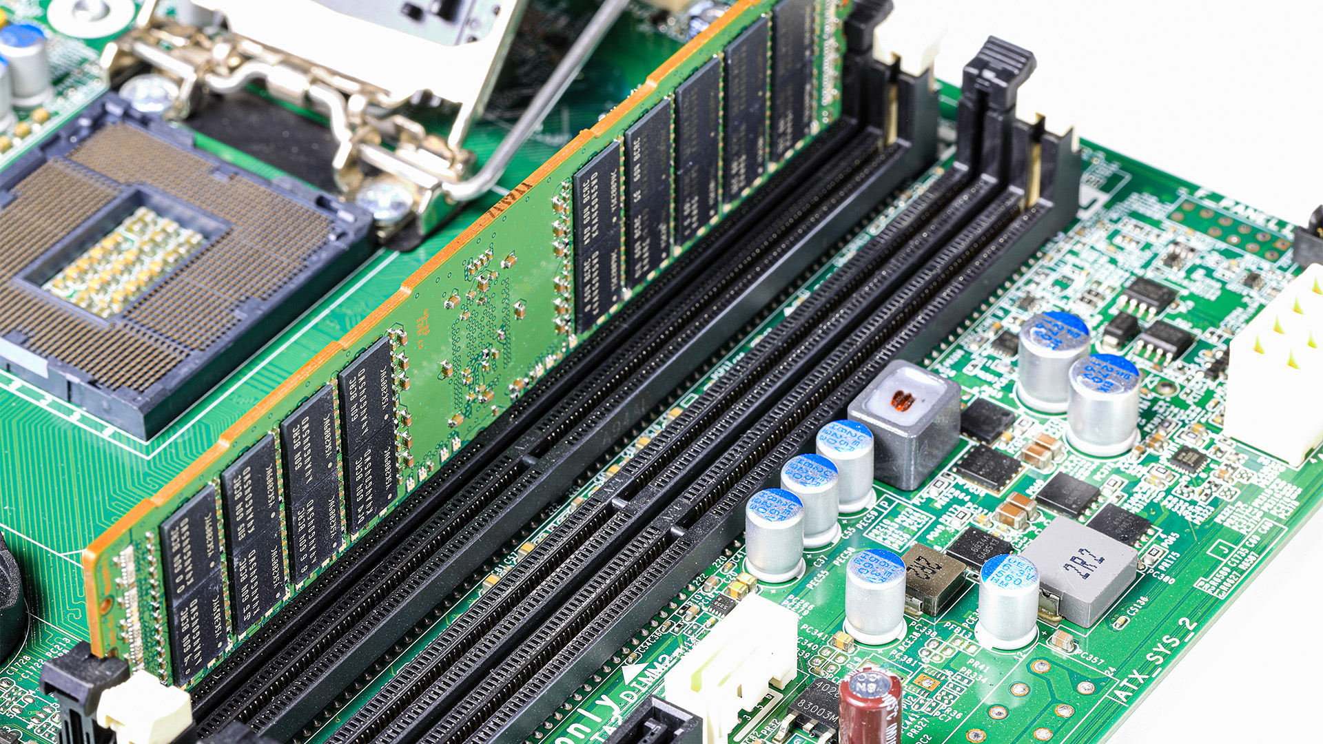 Computer motherboard slots populated with green memory RAM sticks near the CPU socket.