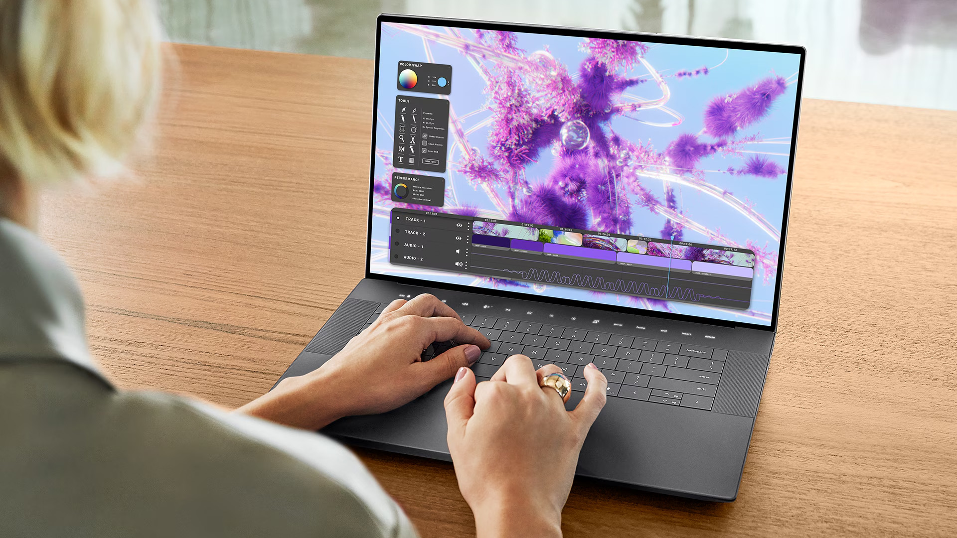 Over-shoulder view of a person editing vibrant 3D graphics on a Dell laptop.