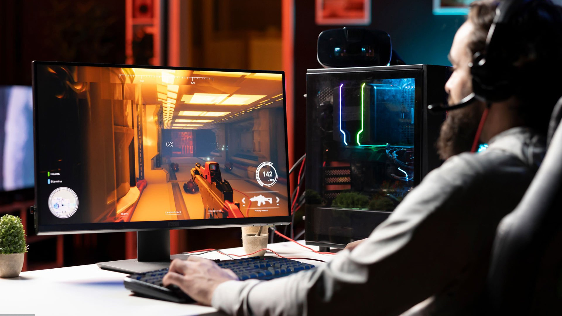 A curved 4K 144Hz gaming monitor displaying a lush green landscape wallpaper on a desk with green RGB lighting.