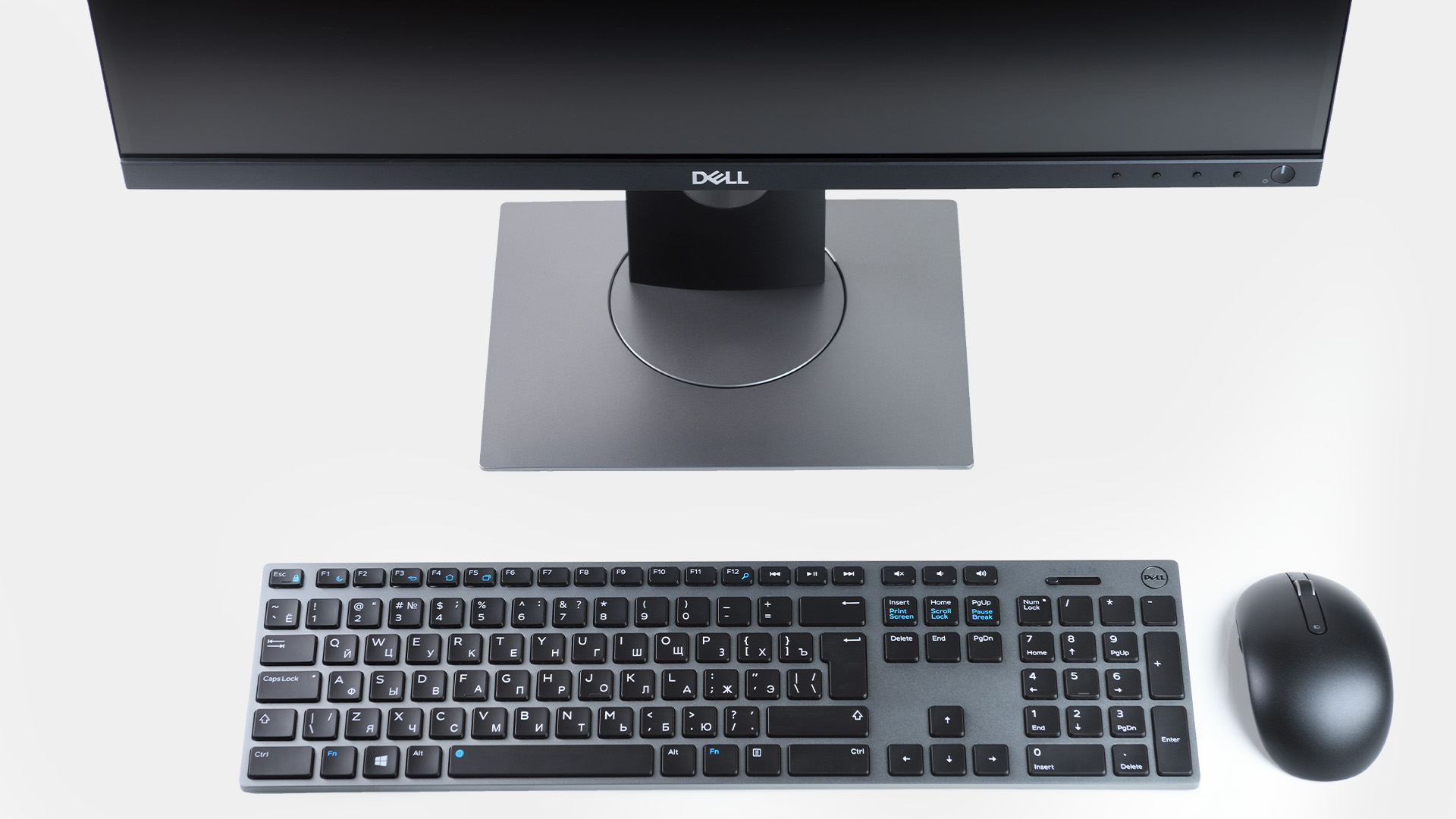 Top view of a Dell monitor with keyboard and mouse on a white desk.