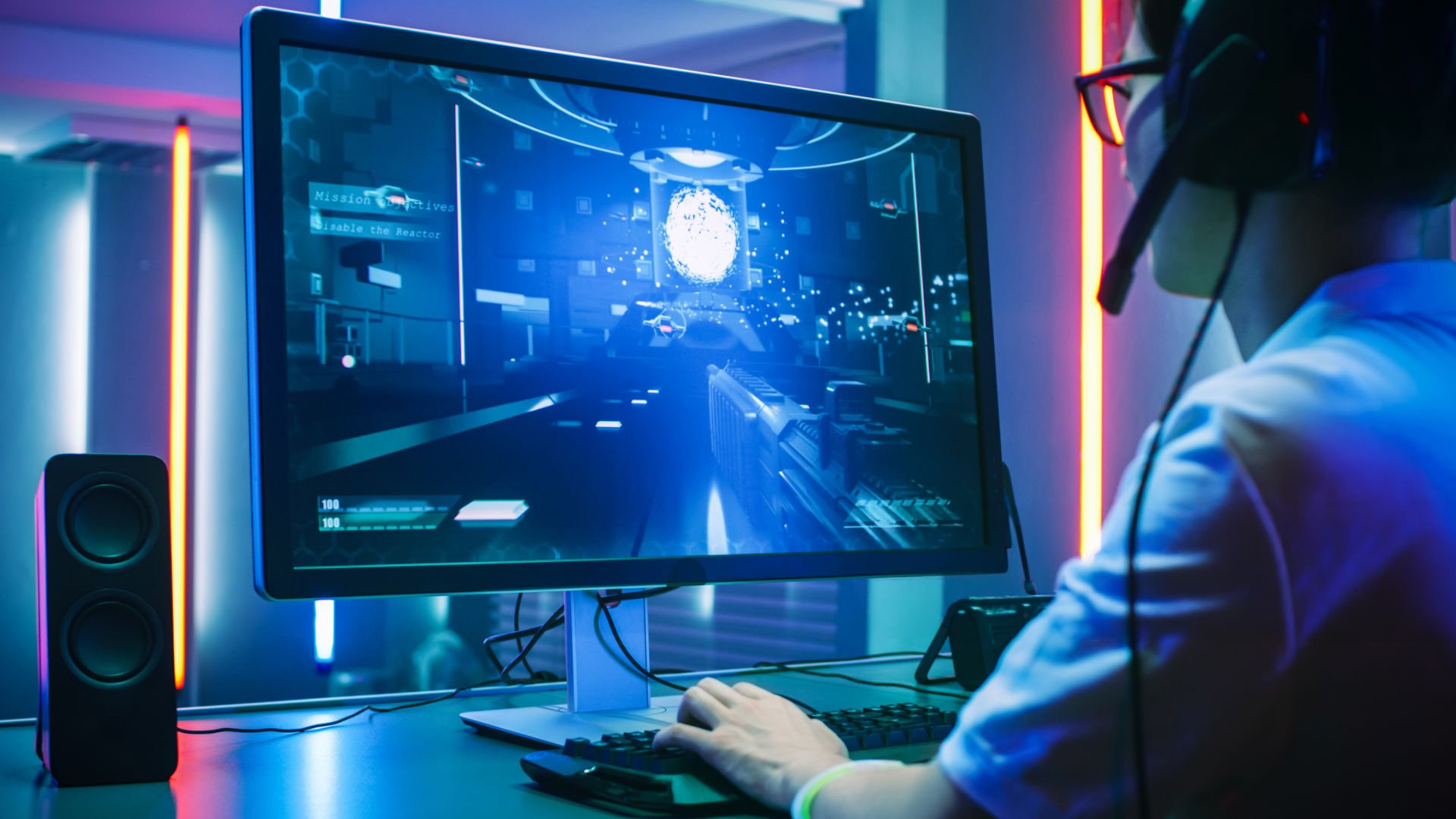 A gamer with headphones playing a shooter game on a high-refresh desktop monitor.