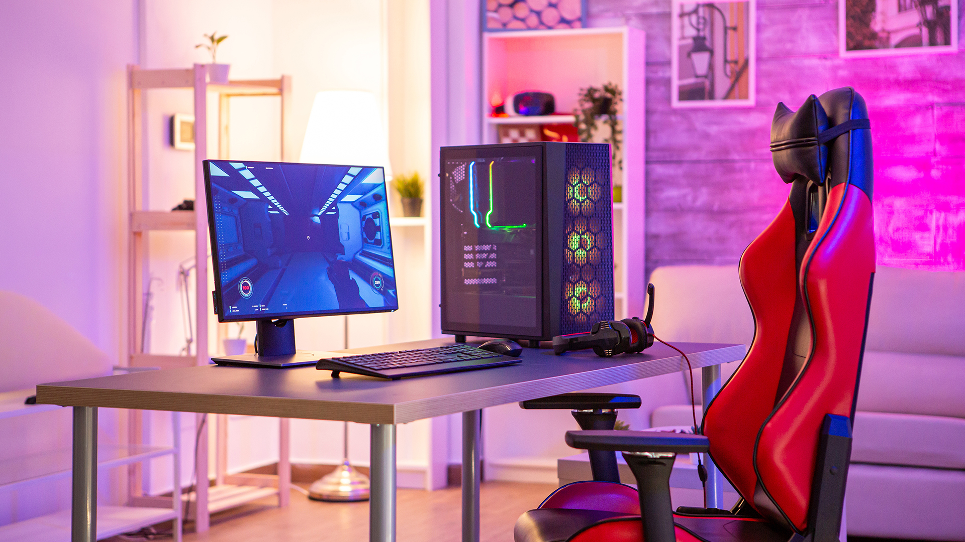 A complete gaming PC setup featuring a monitor and lit tower on a desk.