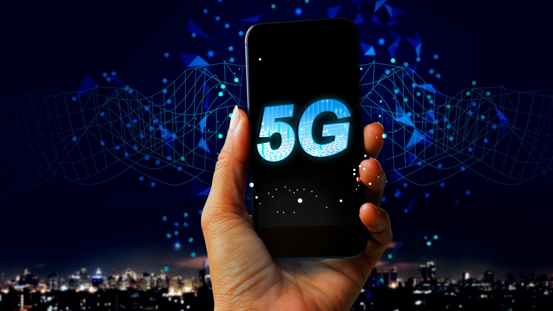 A hand holding a 5G smartphone featuring a glowing 5G logo and connected data lines.