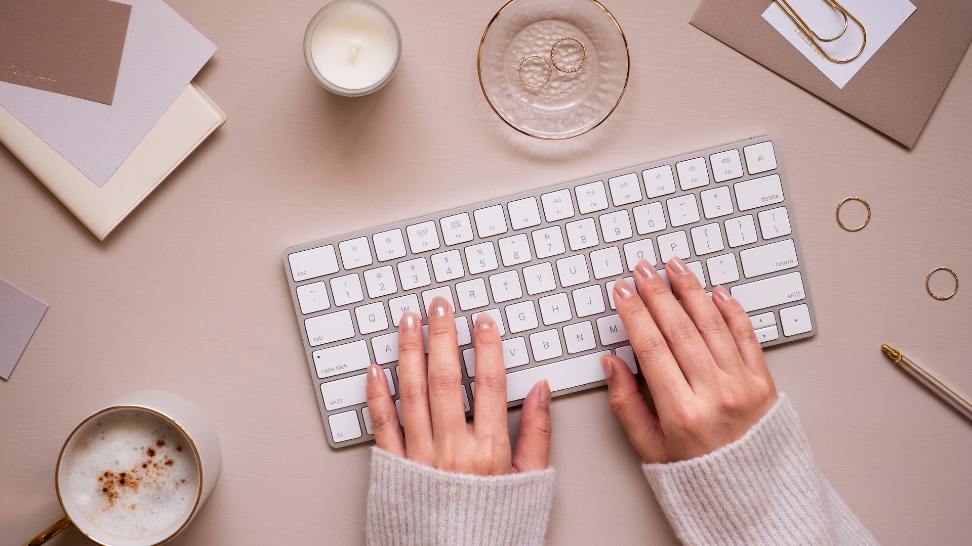 Person typing on a slim white office keyboard.