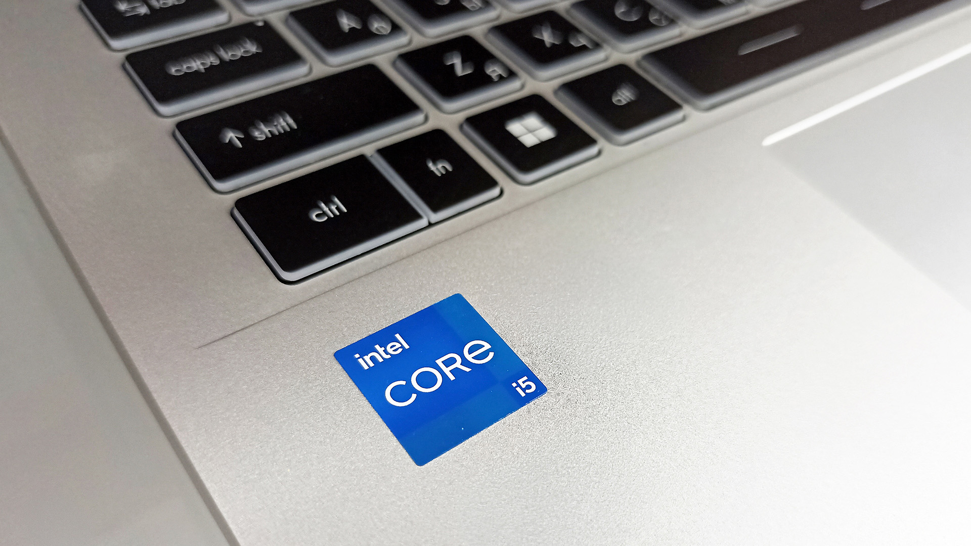 Close-up of an Intel Core i5 processor sticker on a silver laptop.