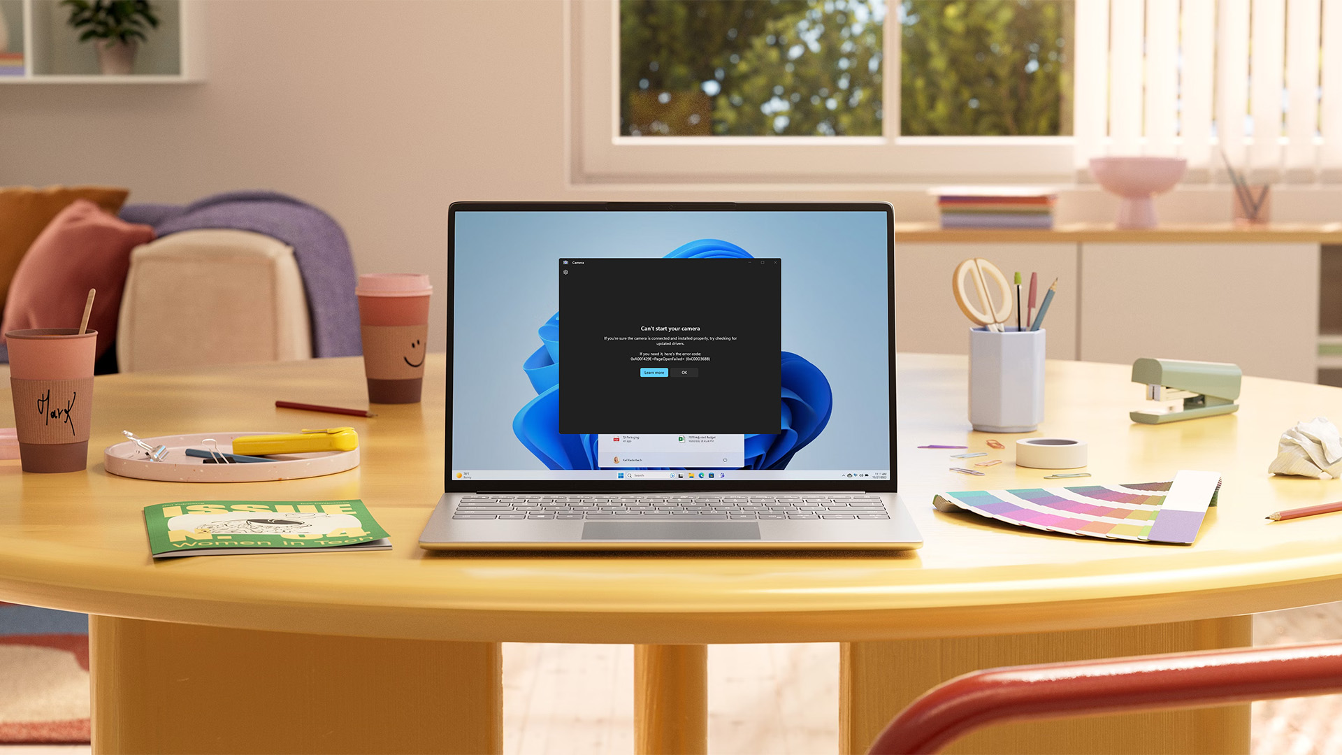 A laptop on a desk showing a webcam error message window.
