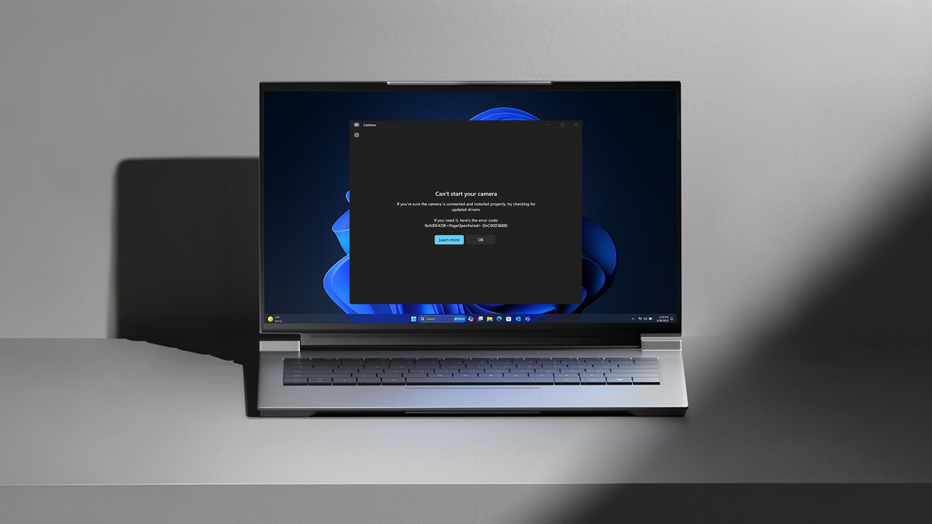 A laptop screen showing a camera connection error message on a grey surface.