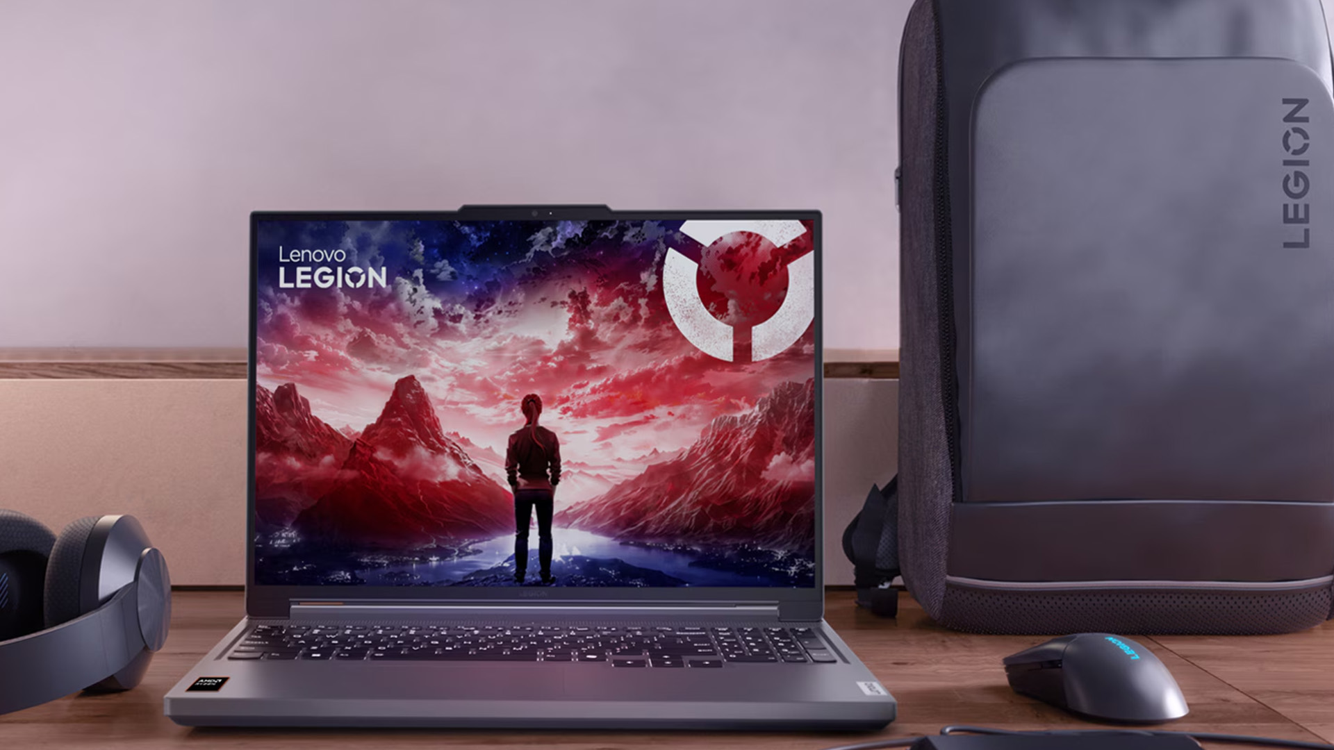 Lenovo Legion laptop displaying a red landscape beside a gaming mouse and backpack.