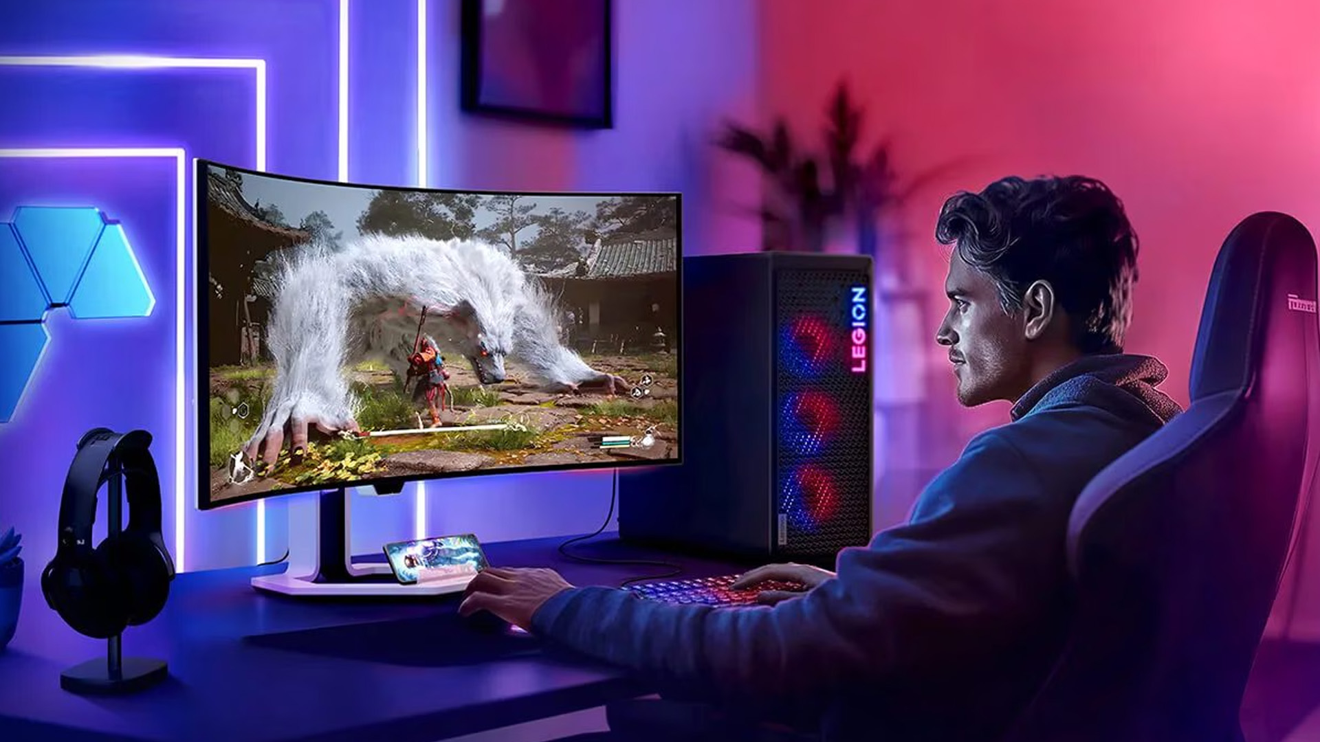 Man playing a video game on a curved Lenovo Legion monitor setup.