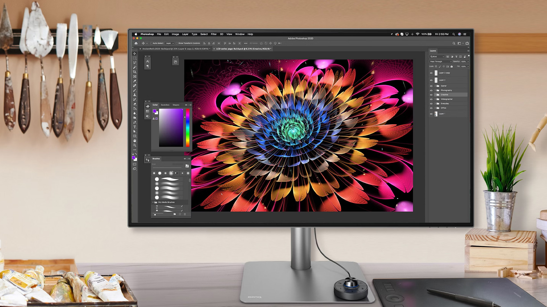 A professional monitor displaying colorful digital flower artwork in Photoshop.