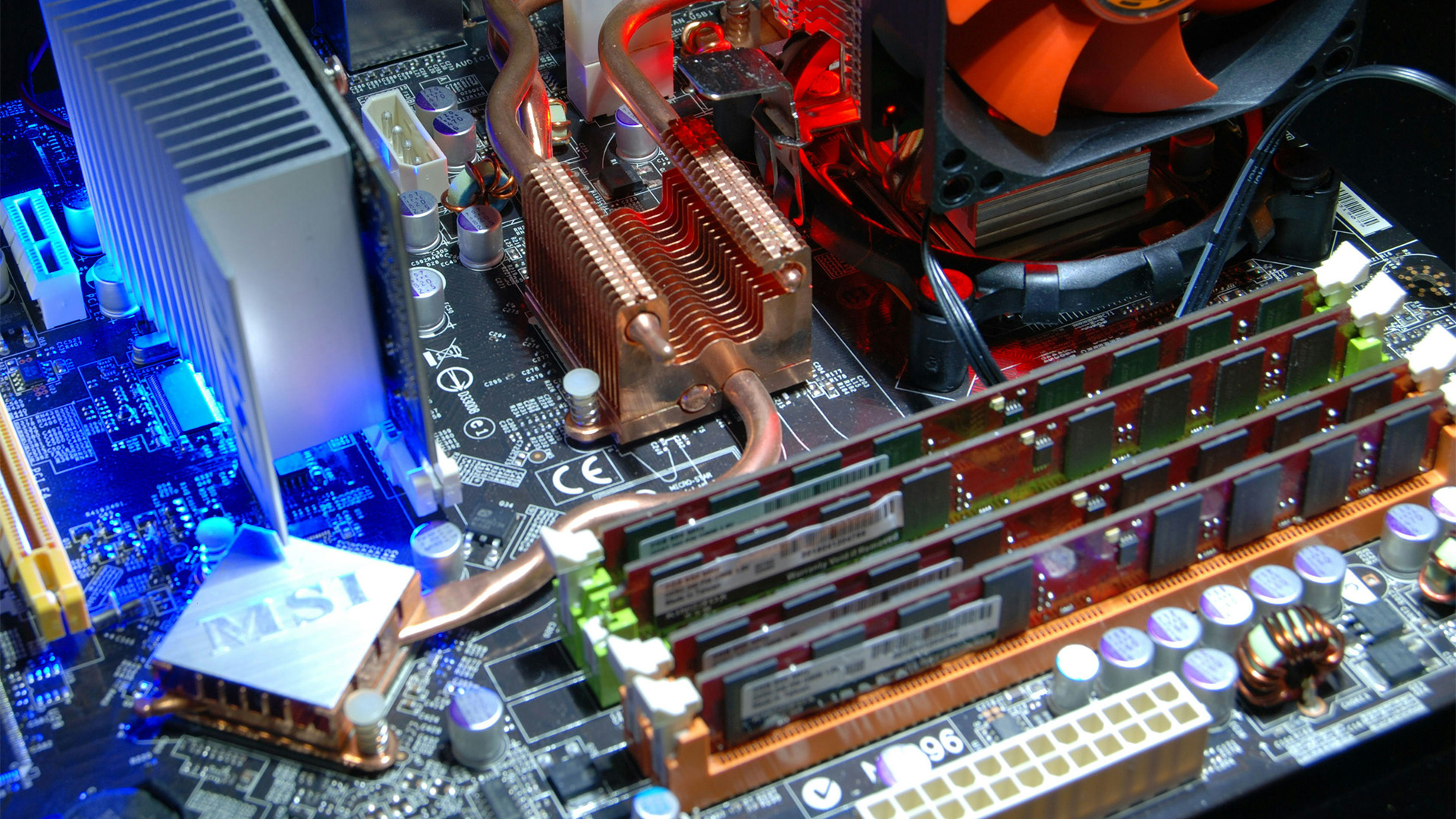 An MSI motherboard featuring copper cooling pipes and four RAM sticks installed in their slots.