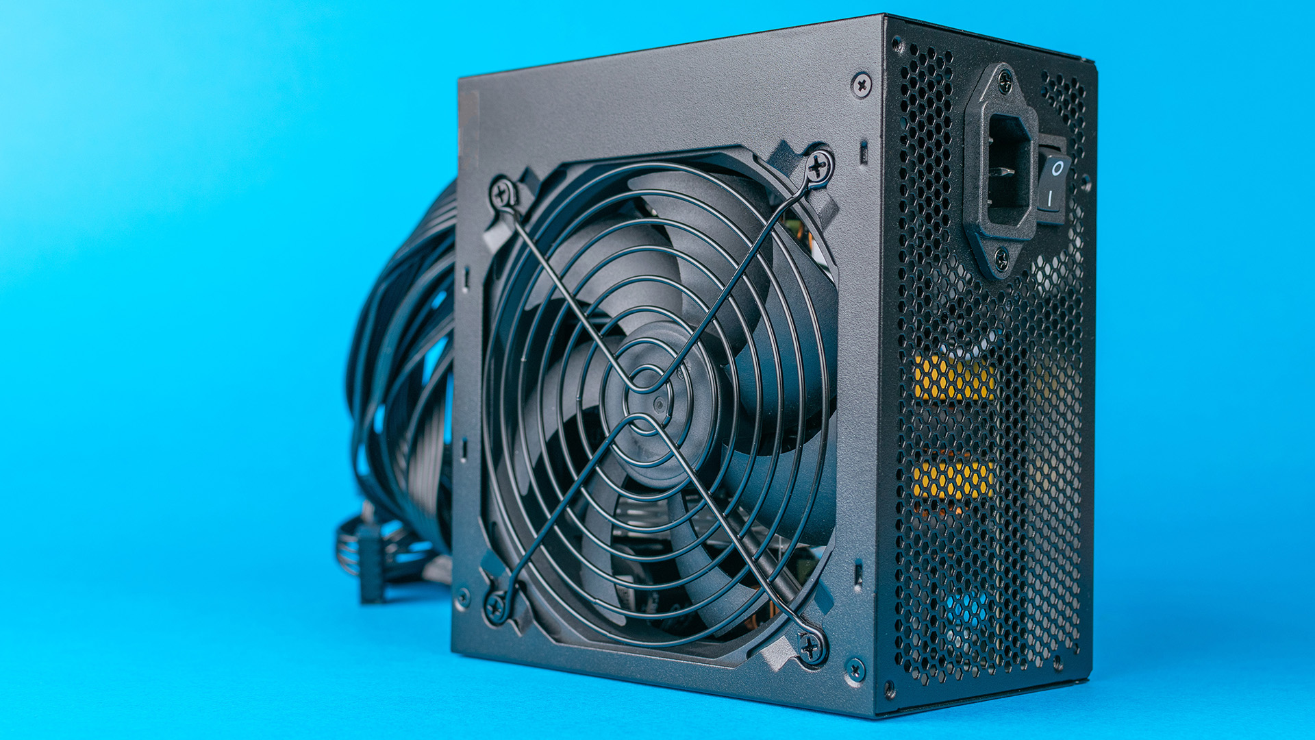 A computer power supply unit photographed against a vibrant blue background.