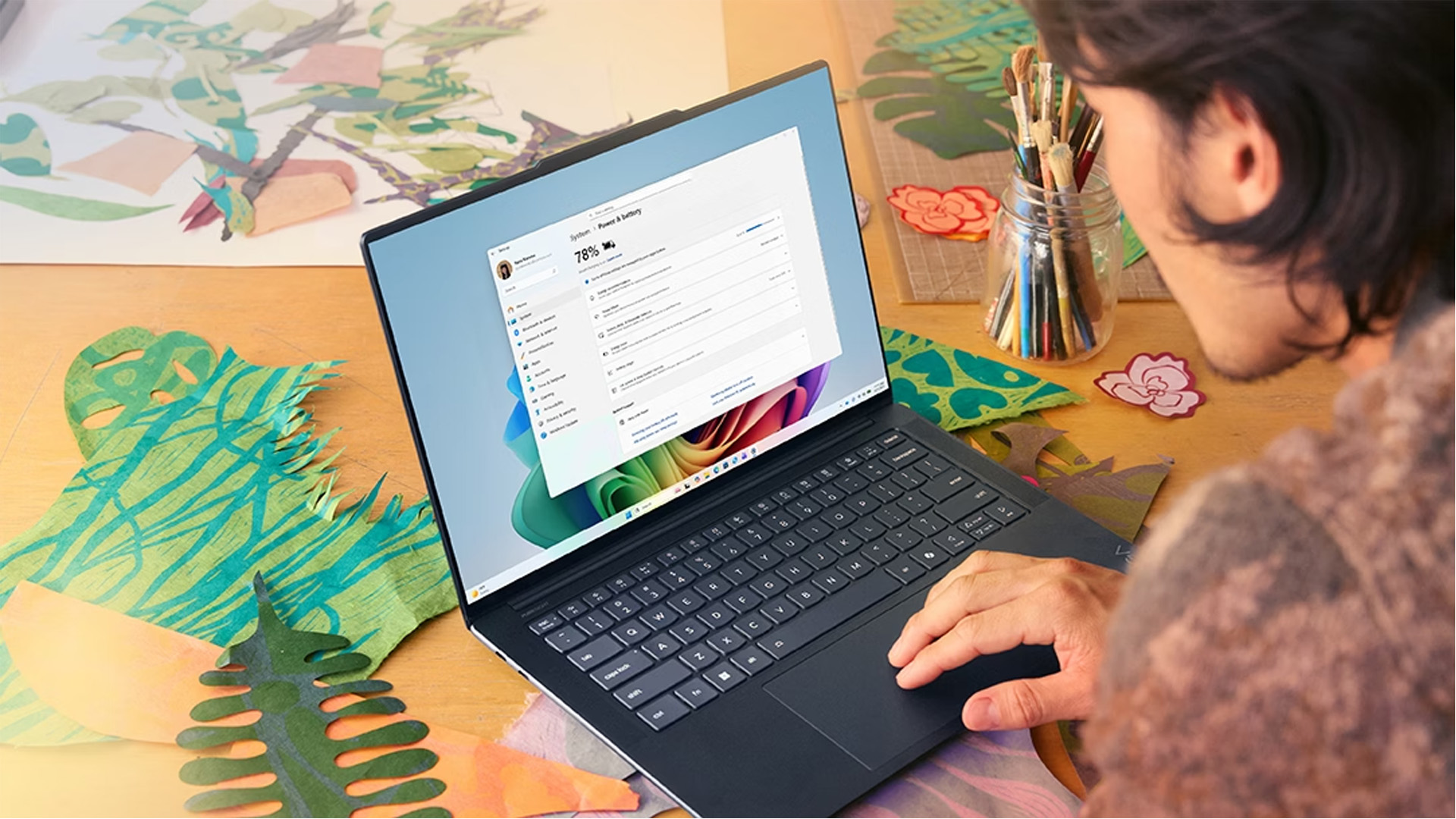 A person checking system settings and power options on a dark Windows 11 laptop.