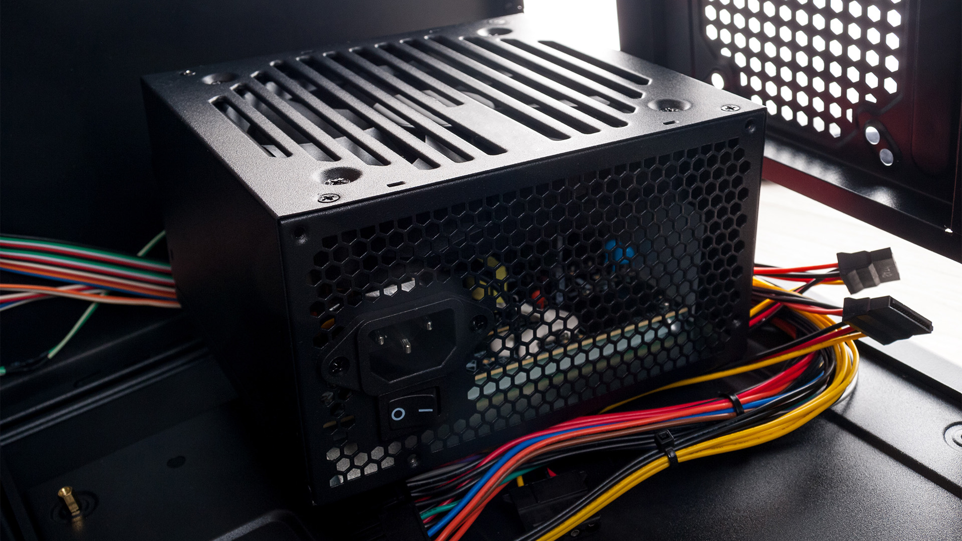 A desktop power supply unit mounted inside a computer chassis with connected cables.