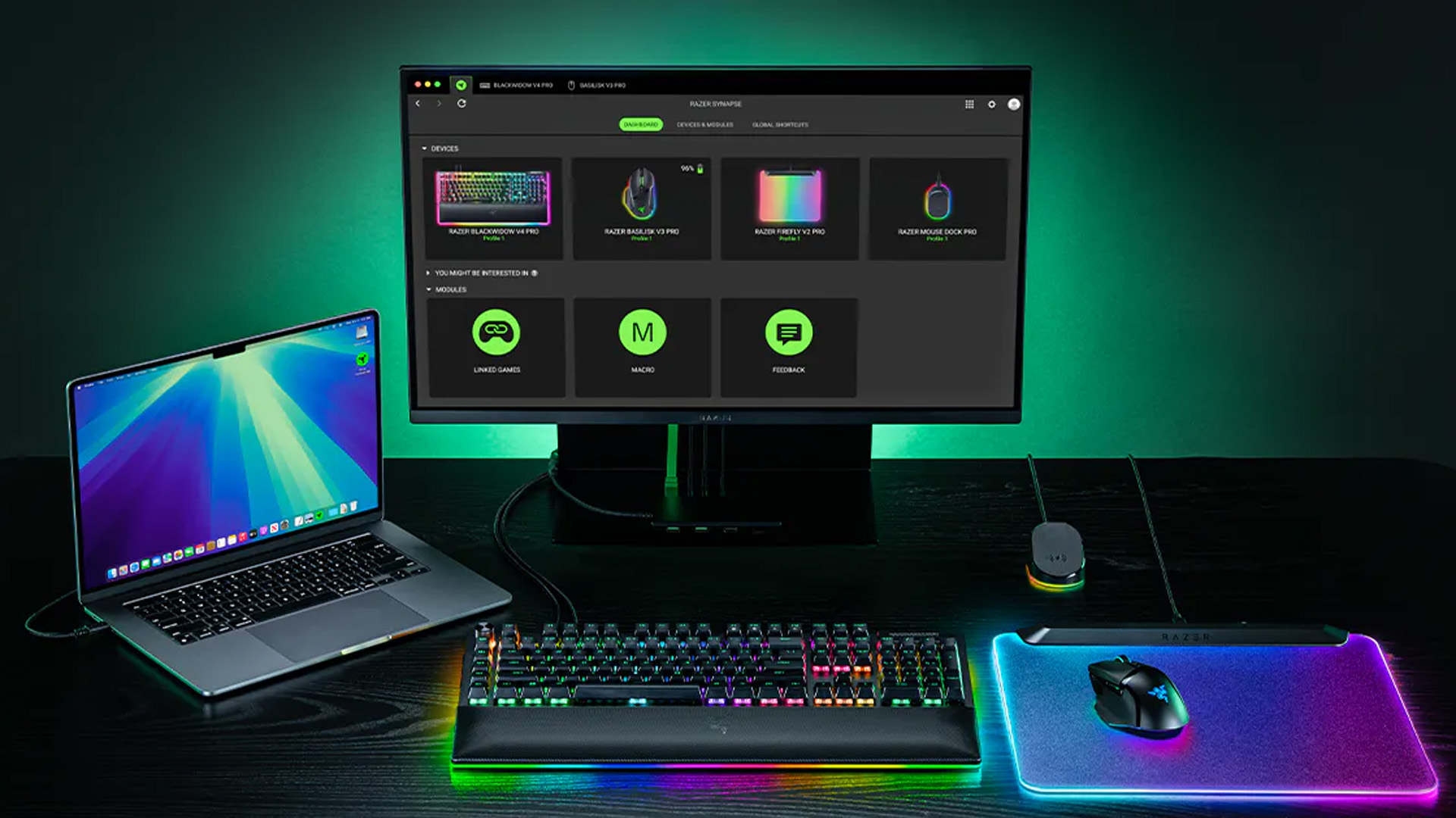 Desk setup showing Razer Synapse on a monitor with a Mac and RGB accessories.