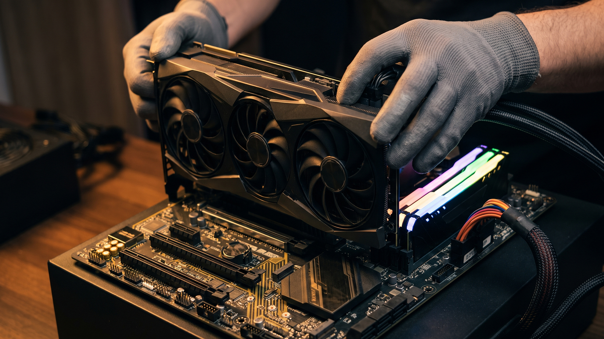 Gloved hands installing a graphics card.