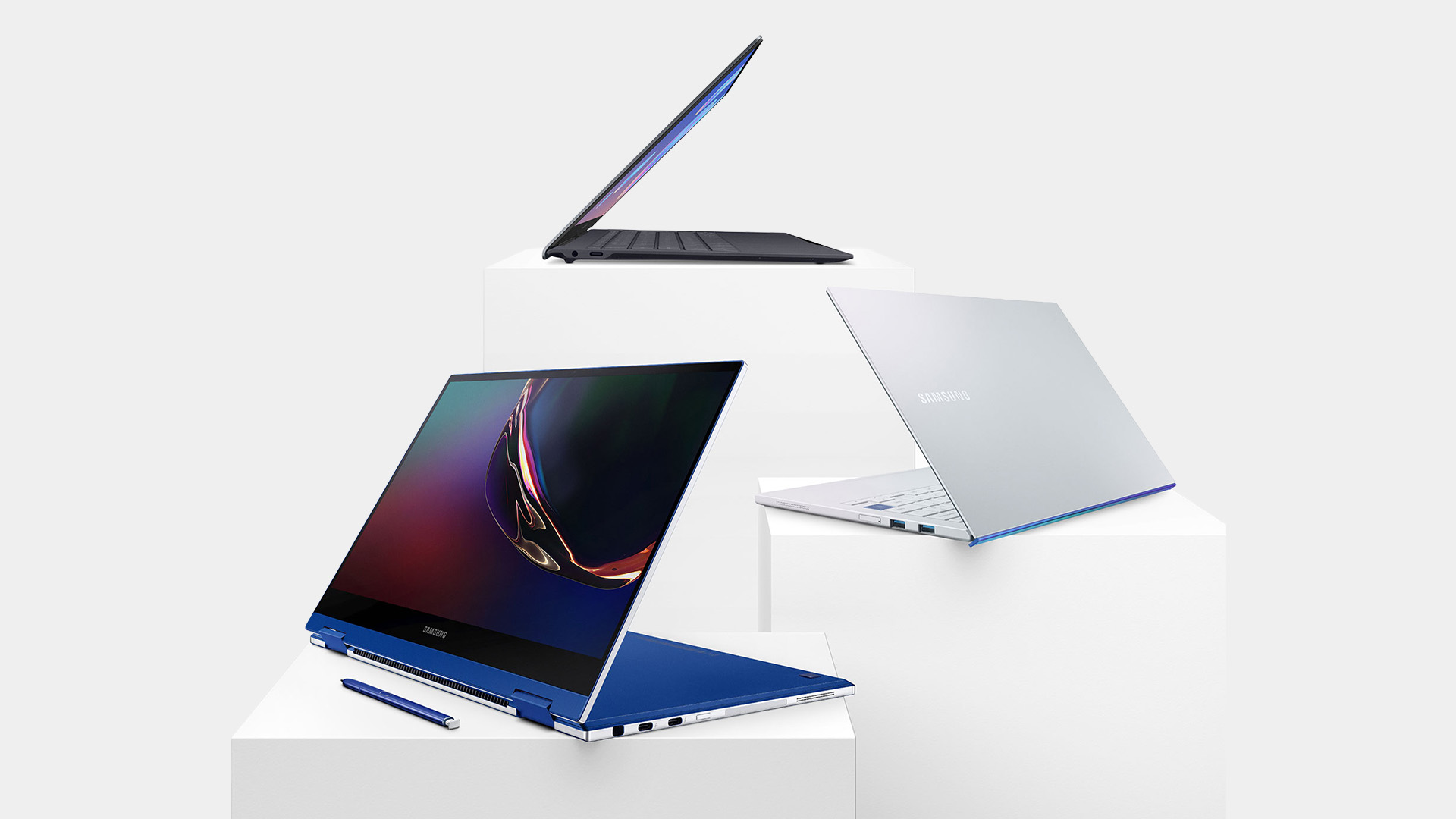 Samsung Galaxy Book laptops and stylus pen displayed on white pedestal stands.