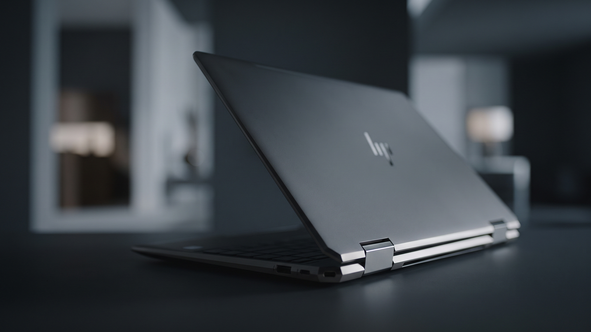 Close-up of a sleek silver HP EliteBook laptop partially open on a desk.