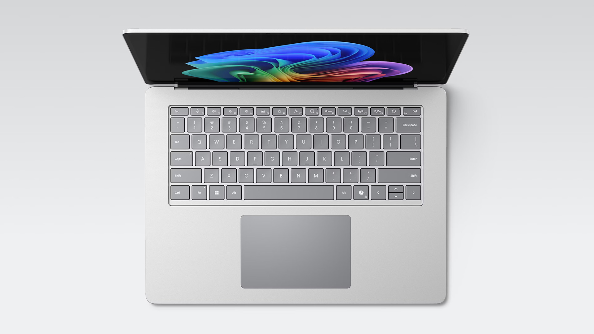 Top-down view of a silver Microsoft Surface laptop keyboard and vibrant screen display.