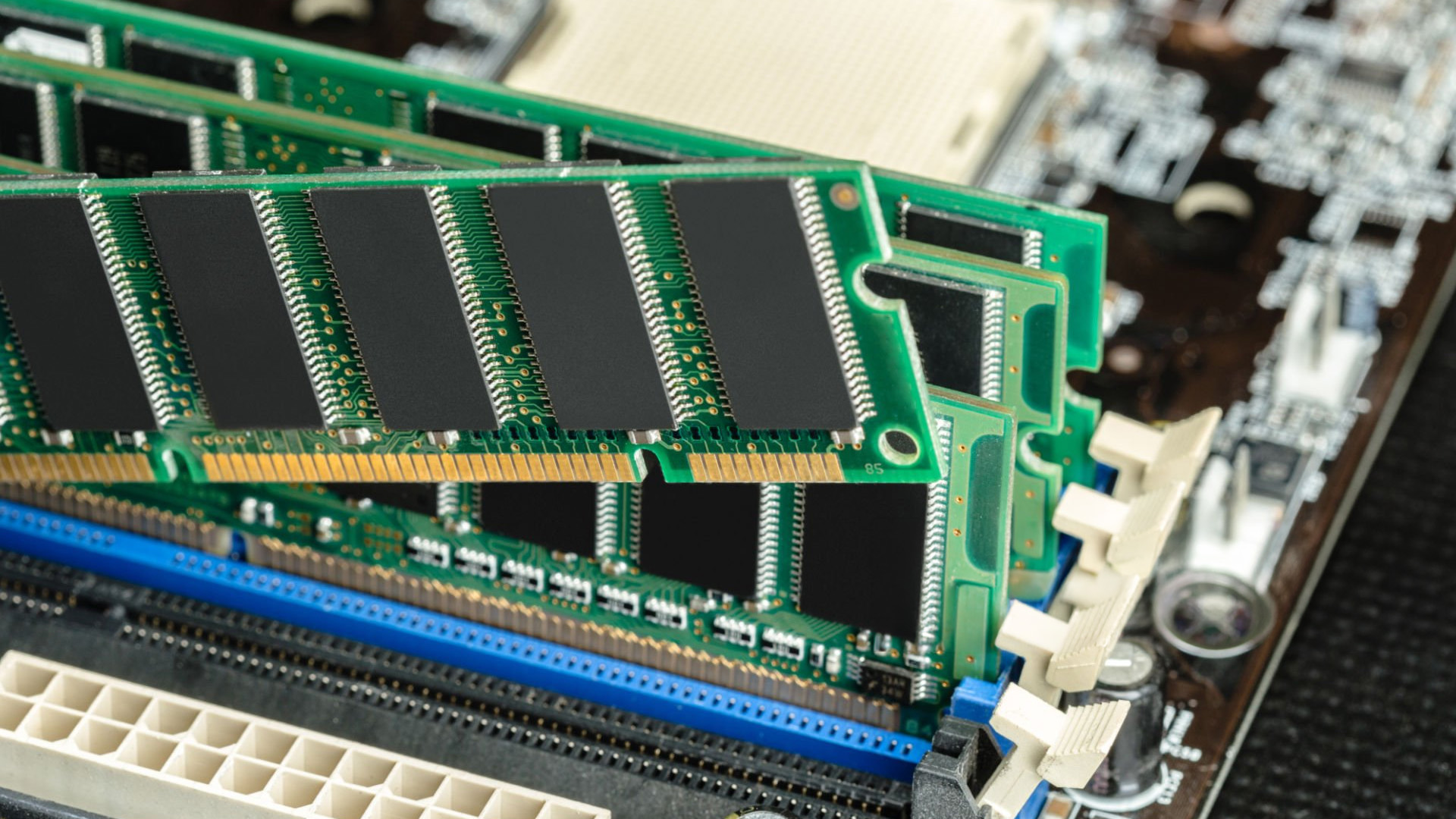 Close-up of two green RAM sticks securely installed in a computer motherboard slot.