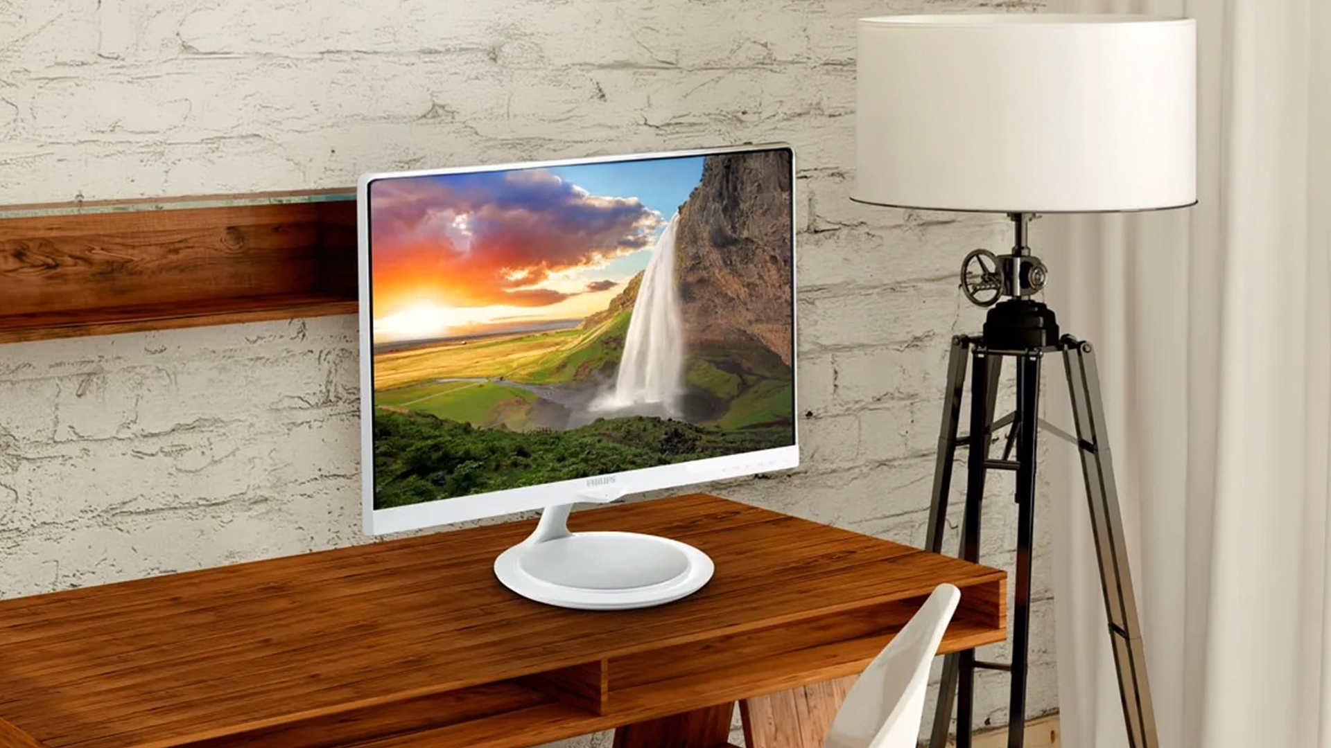 White Philips 4K monitor displaying a waterfall landscape on a wooden desk.