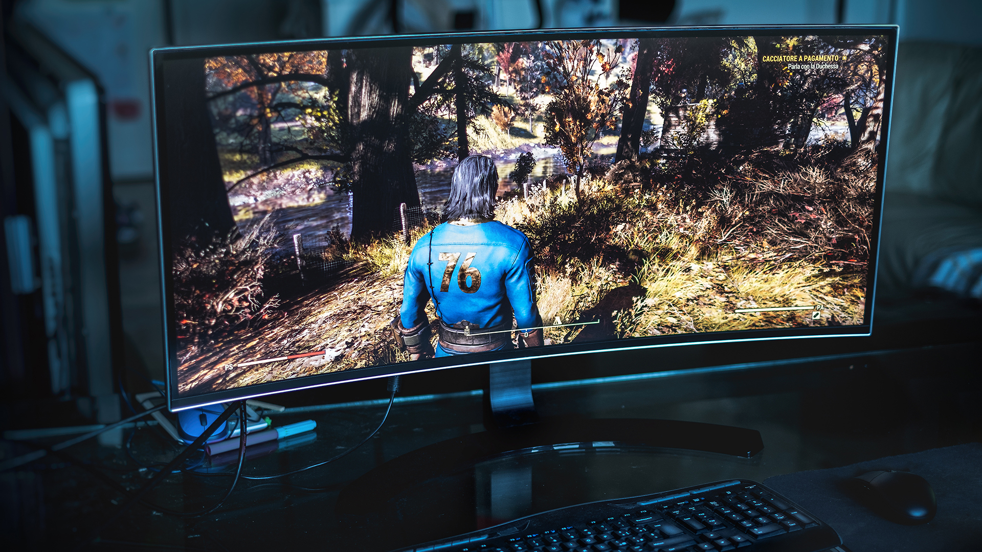 Close-up of a widescreen gaming monitor displaying an open-world video game scene.